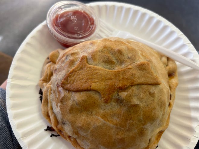 A baked pasty rests on a plate.